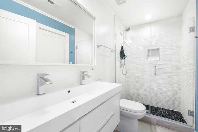 bathroom with vanity, toilet, and a shower with door