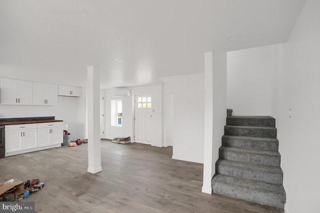 foyer entrance with hardwood / wood-style floors and a wall mounted air conditioner