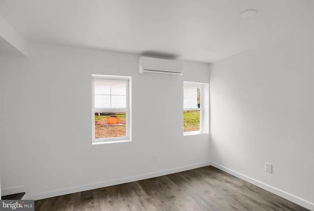 unfurnished room featuring dark hardwood / wood-style flooring and an AC wall unit