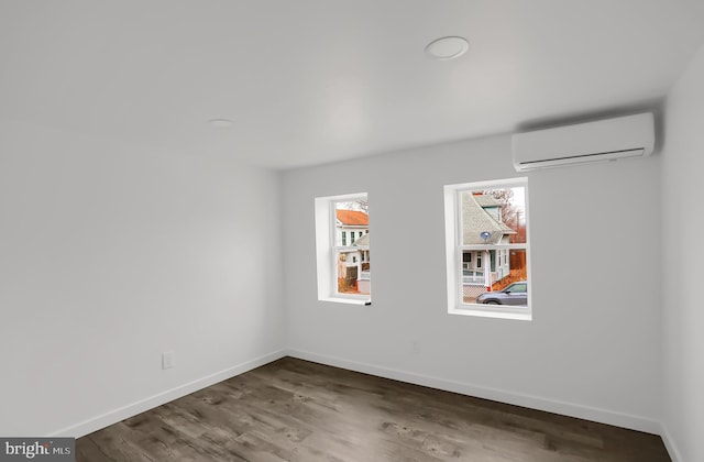 spare room with a wall mounted air conditioner and wood-type flooring