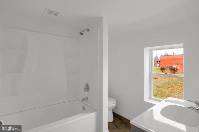 full bathroom with bathing tub / shower combination, plenty of natural light, vanity, and toilet