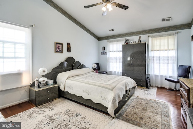 bedroom with hardwood / wood-style flooring, ceiling fan, lofted ceiling with beams, and multiple windows