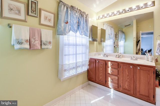 bathroom with tile patterned flooring, vanity, and vaulted ceiling