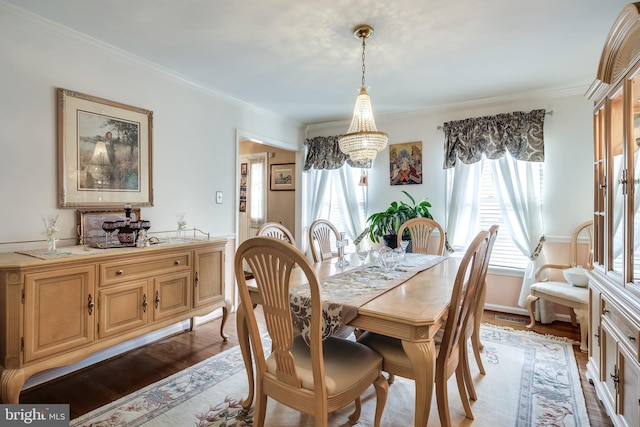 dining space with crown molding, light hardwood / wood-style floors, and a notable chandelier