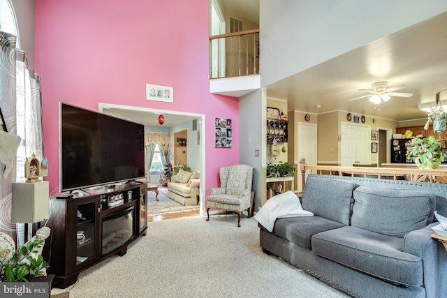 living room with carpet, a towering ceiling, and ceiling fan