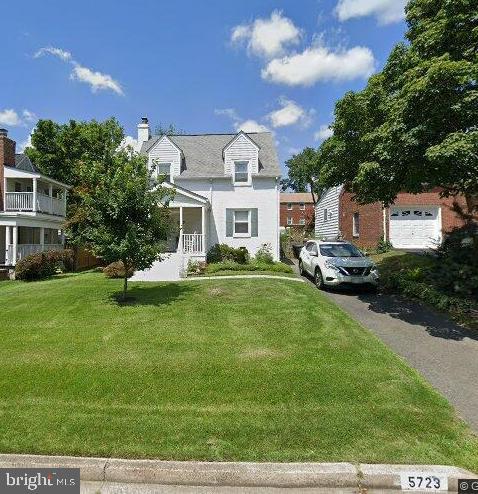 cape cod-style house featuring a porch and a front lawn