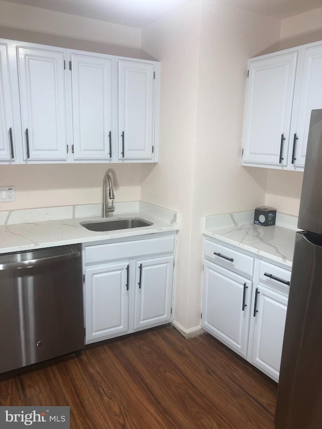 kitchen with white cabinetry, sink, stainless steel appliances, light stone counters, and dark hardwood / wood-style floors