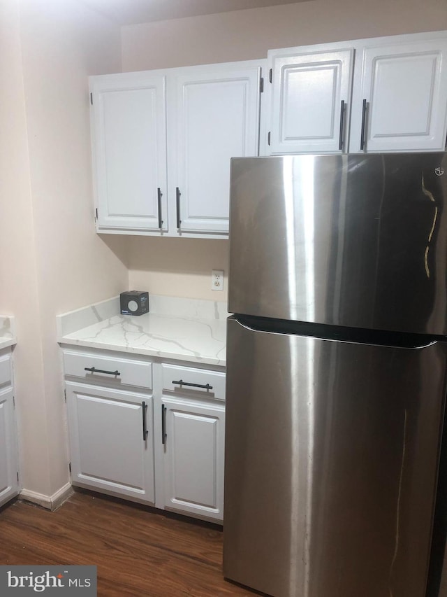 kitchen featuring stainless steel refrigerator, white cabinets, and dark wood-type flooring