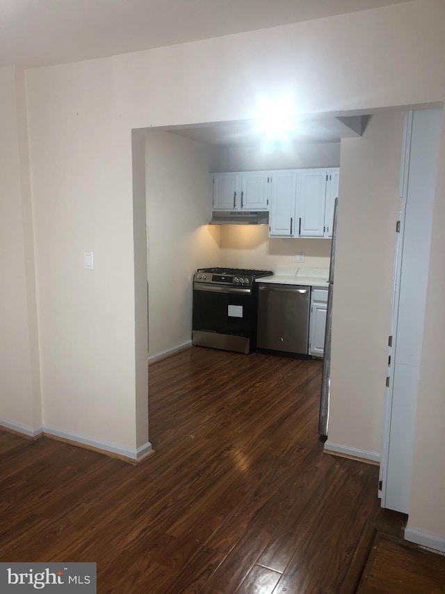 kitchen with white cabinets, dark hardwood / wood-style floors, and appliances with stainless steel finishes