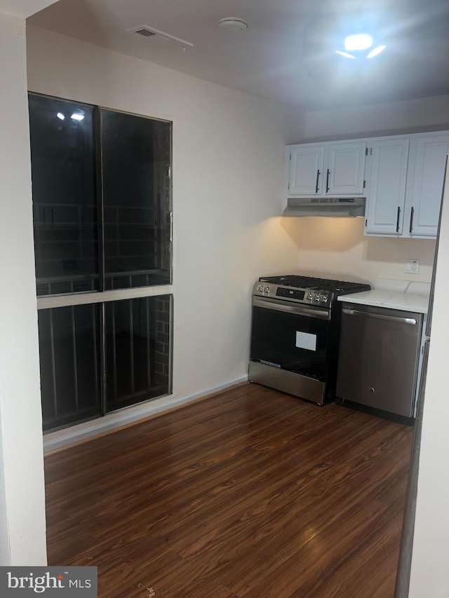 kitchen featuring dark hardwood / wood-style floors, white cabinetry, and stainless steel appliances