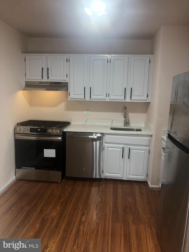 kitchen with appliances with stainless steel finishes, white cabinetry, and sink