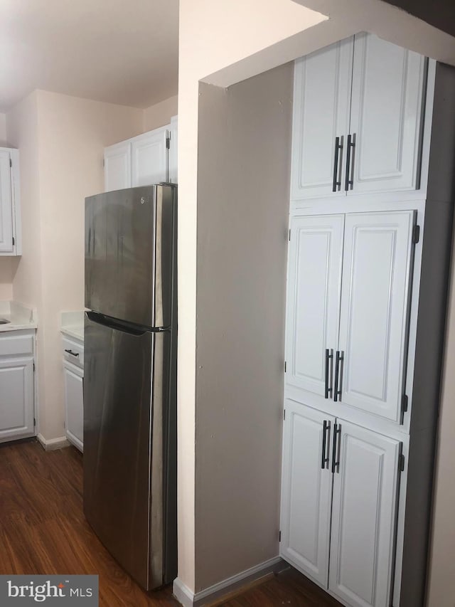 kitchen featuring white cabinets, stainless steel refrigerator, and dark wood-type flooring