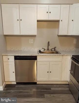 kitchen with dark hardwood / wood-style flooring, white cabinetry, sink, and appliances with stainless steel finishes