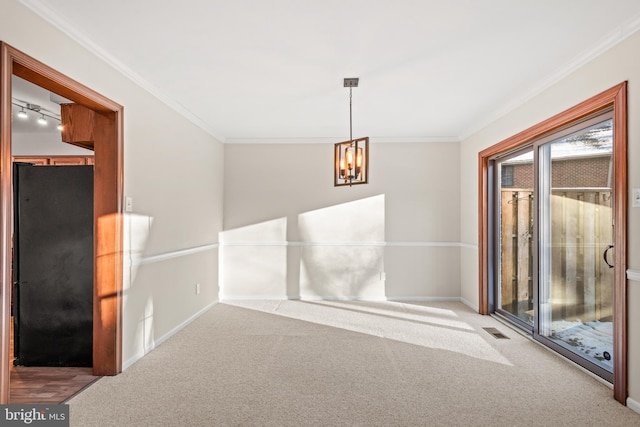 carpeted spare room with a notable chandelier and crown molding