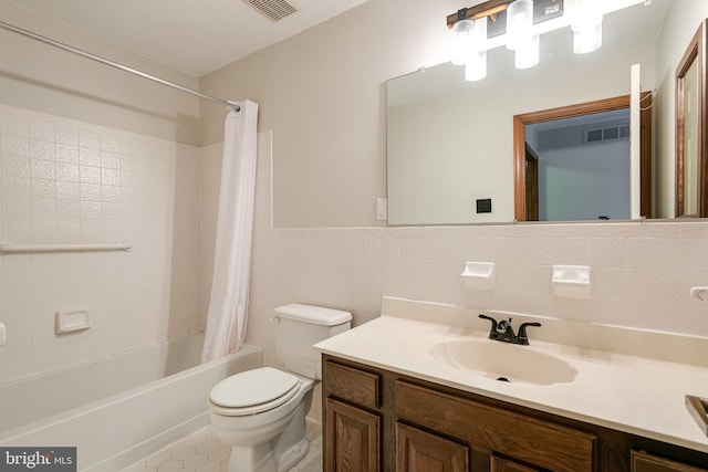 full bathroom featuring shower / tub combo, tile patterned floors, vanity, tile walls, and toilet