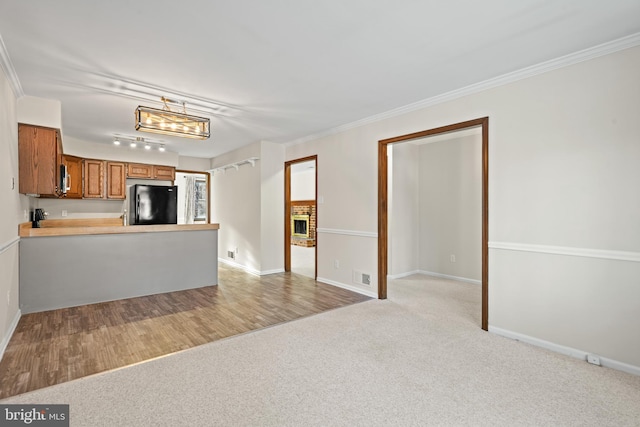 unfurnished living room with light colored carpet and ornamental molding