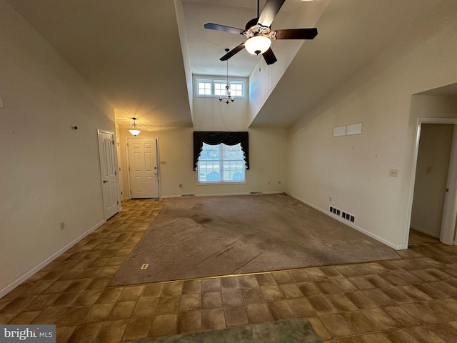 unfurnished living room with a towering ceiling, carpet floors, and ceiling fan