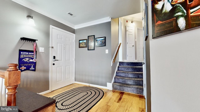 foyer with hardwood / wood-style flooring and crown molding