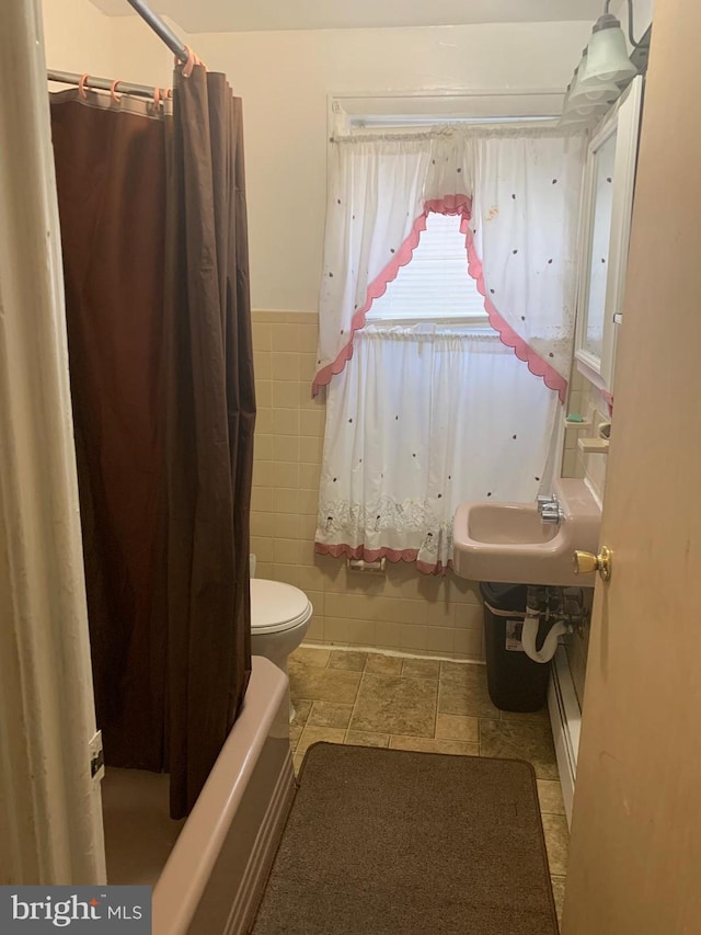 full bathroom with sink, toilet, shower / bath combo with shower curtain, and tile walls