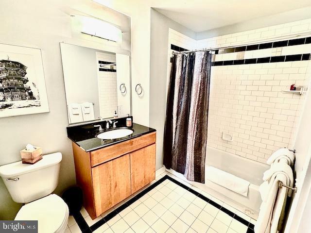 full bathroom with tile patterned floors, vanity, toilet, and shower / bath combo with shower curtain