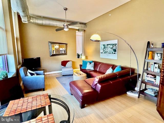 living room featuring ceiling fan and hardwood / wood-style flooring