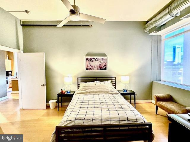 bedroom with multiple windows, ceiling fan, and light hardwood / wood-style floors