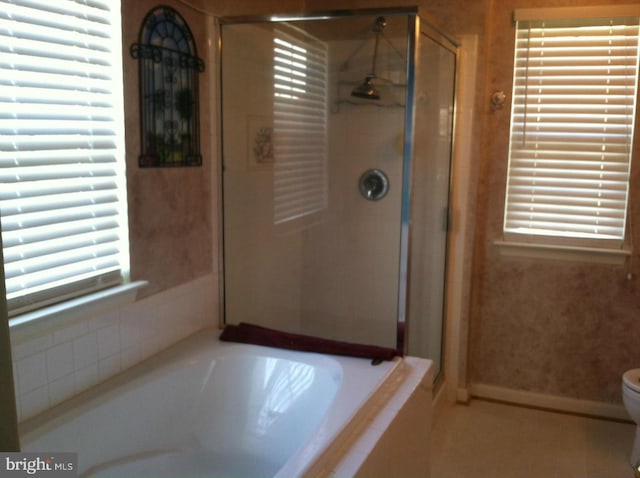 bathroom with a healthy amount of sunlight, toilet, and independent shower and bath