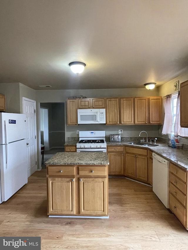 kitchen with light stone countertops, sink, white appliances, and light hardwood / wood-style flooring