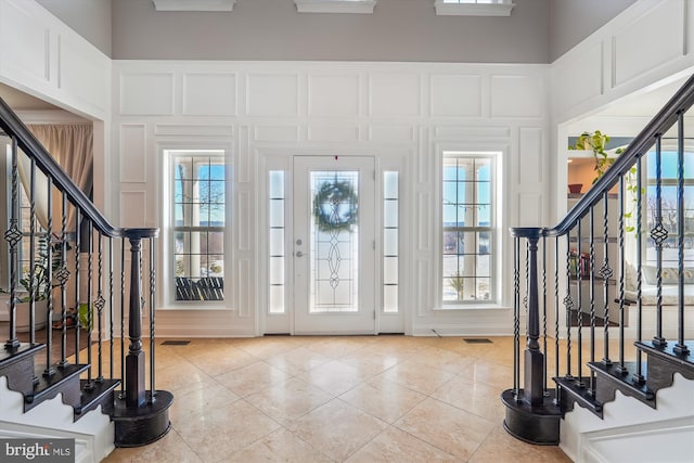 foyer entrance featuring light tile patterned floors and a healthy amount of sunlight