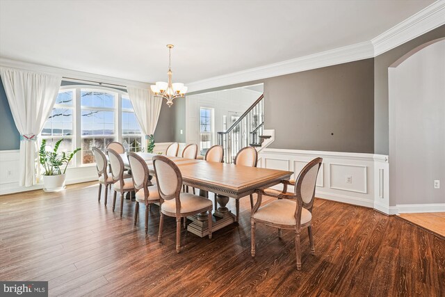 dining room with a notable chandelier, hardwood / wood-style floors, and crown molding