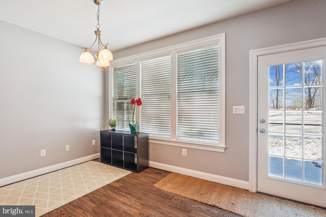 entryway featuring a healthy amount of sunlight, a chandelier, and hardwood / wood-style flooring