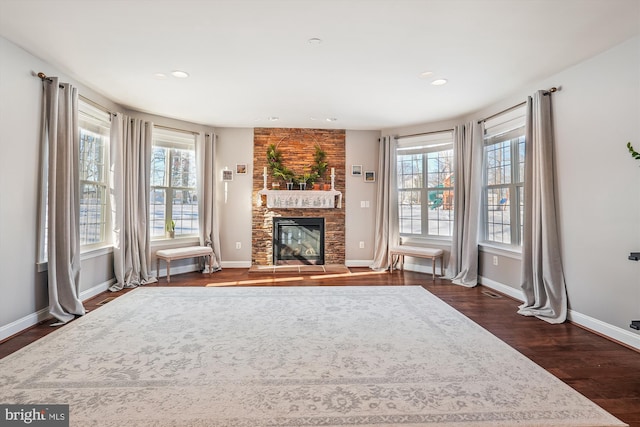 unfurnished living room with dark hardwood / wood-style flooring and a fireplace