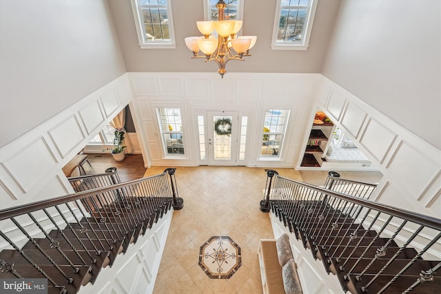 foyer featuring a high ceiling, plenty of natural light, and a chandelier