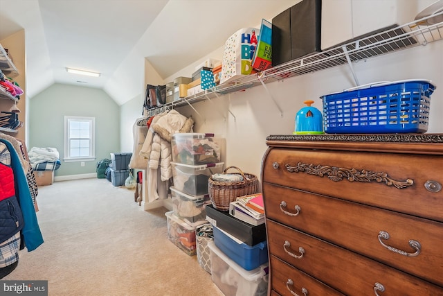 spacious closet with lofted ceiling and light colored carpet