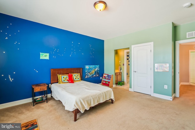 bedroom with connected bathroom and carpet