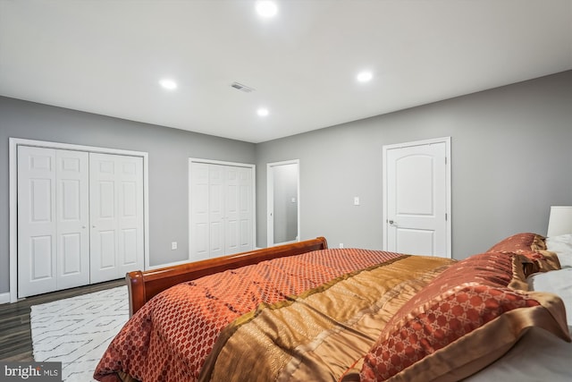 bedroom featuring two closets and dark hardwood / wood-style flooring