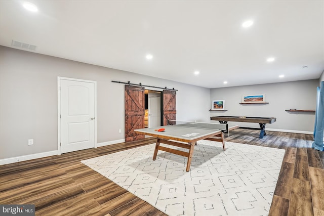 playroom featuring pool table, light hardwood / wood-style floors, and a barn door