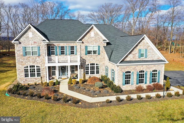 view of front of property with a balcony and a front lawn