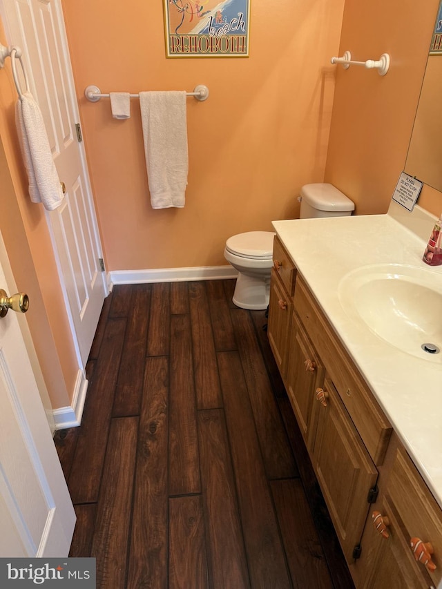 bathroom with hardwood / wood-style flooring, vanity, and toilet