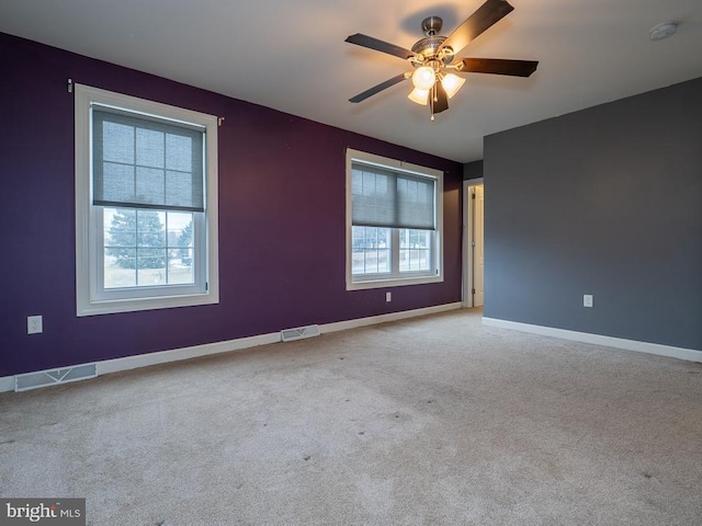 unfurnished room with light colored carpet and ceiling fan