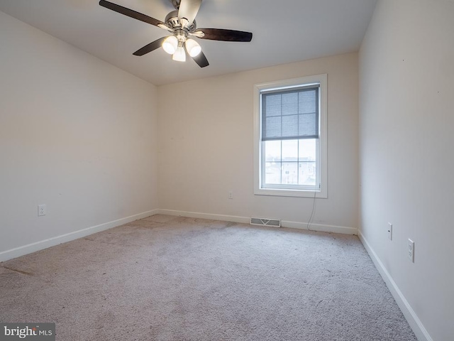 carpeted spare room featuring ceiling fan