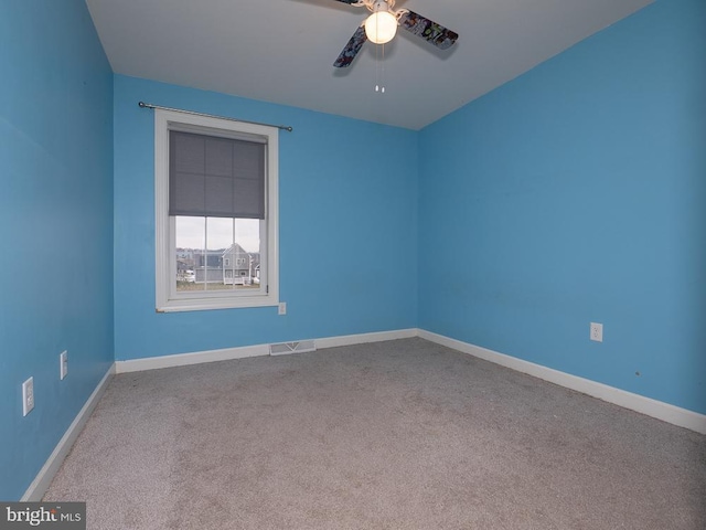 empty room featuring ceiling fan and carpet