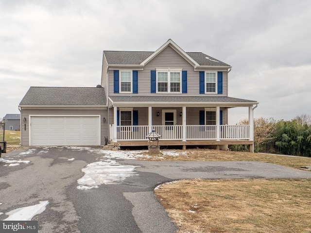 view of front of home with a porch, a front lawn, and a garage