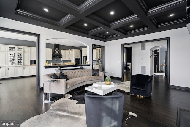 living room featuring beam ceiling, dark wood-type flooring, crown molding, and coffered ceiling