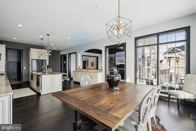 dining space featuring dark wood-type flooring and an inviting chandelier