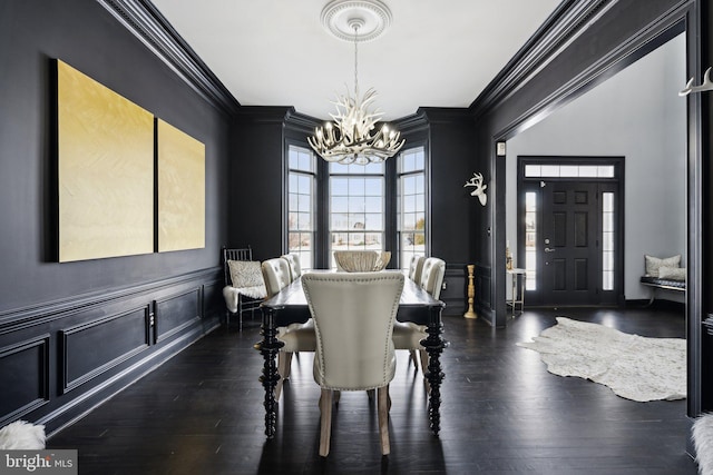 dining space featuring a notable chandelier, dark hardwood / wood-style flooring, and ornamental molding