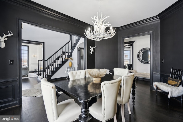 dining space with a notable chandelier, crown molding, and dark wood-type flooring