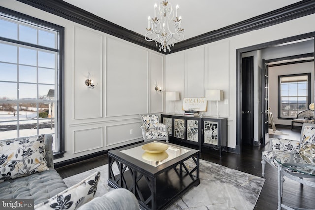 living room with crown molding, dark wood-type flooring, and a notable chandelier