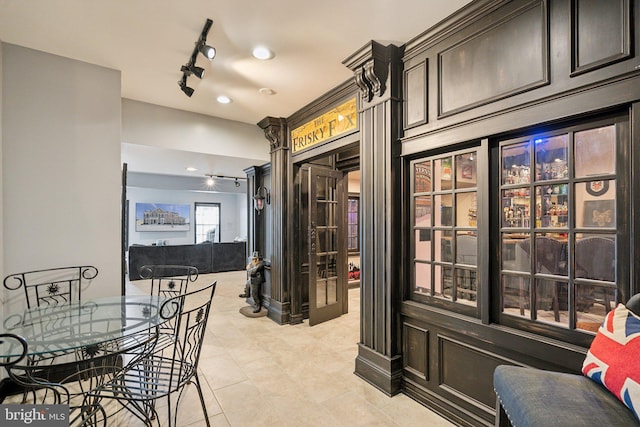 dining space with light tile patterned floors and track lighting