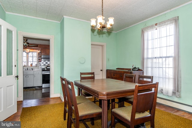 dining room featuring ceiling fan with notable chandelier, sink, ornamental molding, baseboard heating, and dark hardwood / wood-style flooring